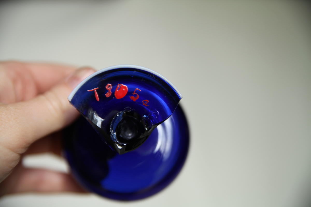 Blått glass med hvit kant rundt fot og topp