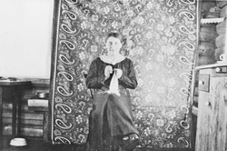 Kvinne som sitter og hekler.