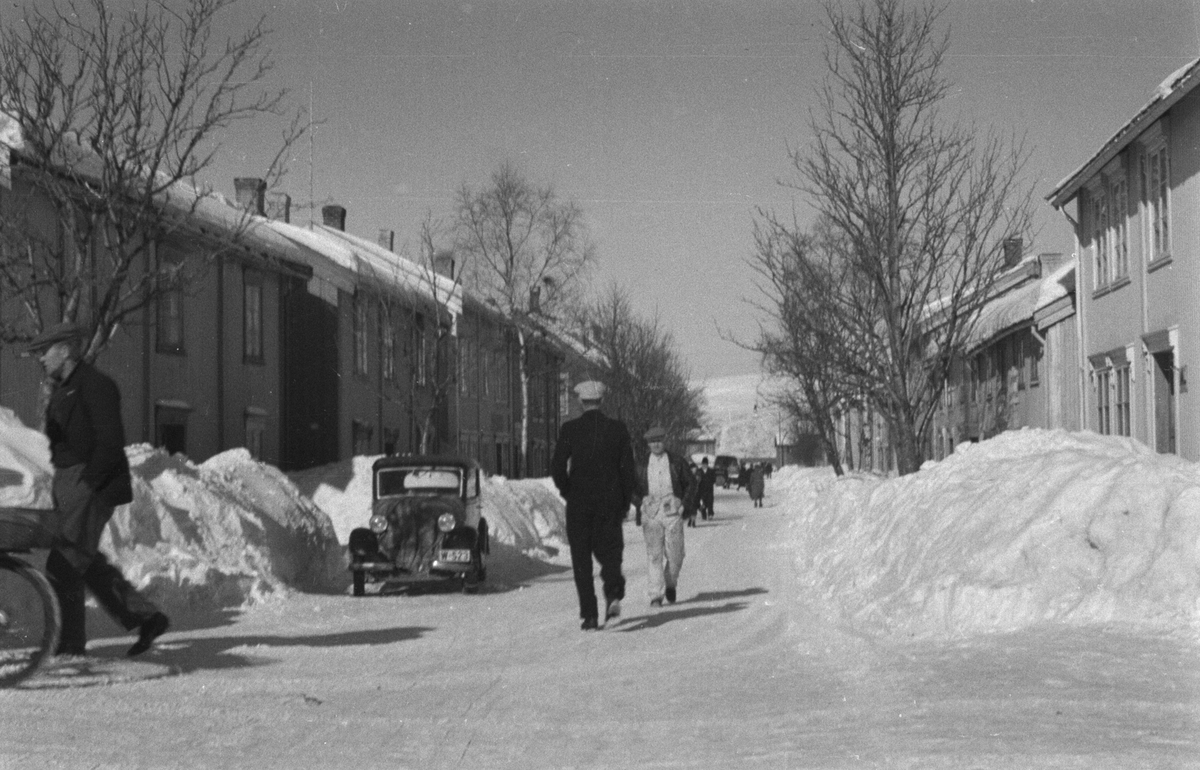 Fra Krysset Petter Dassgt. nedover Strandgata. Vinter, folk i gata. Til høyre ser vi Strandgata 22, til venstre nr.17