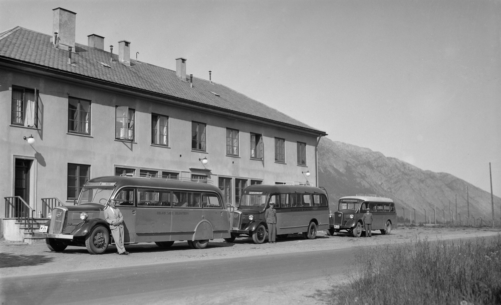 Tre bussser  og sjåfører tilhørende Helgeland Bilruter parkert fremfor Mosjøen Jernbanestasjon. Bussene er av merket Volvo