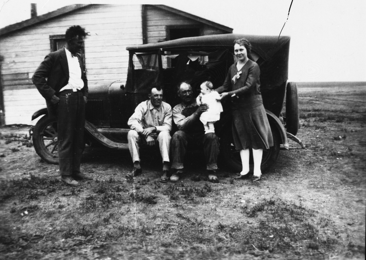 Fem personer foran en gammel Chevrolet.
Bildet er tatt i Canada i tidsrommet 1927-32.