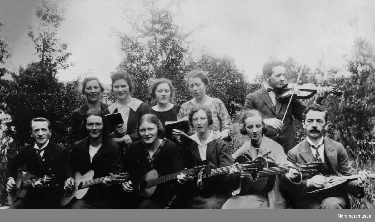Strengemusikk: 5 gitarer, mandolin og fele, 4 damer, jenter synger. Misjon? Forening. Fritid, underhodning. 1930-tall. Nordmøre museums fotosamling
