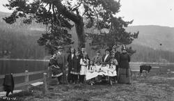 Familiebilde. Familien Holta (?) oppstilt foran et vann.