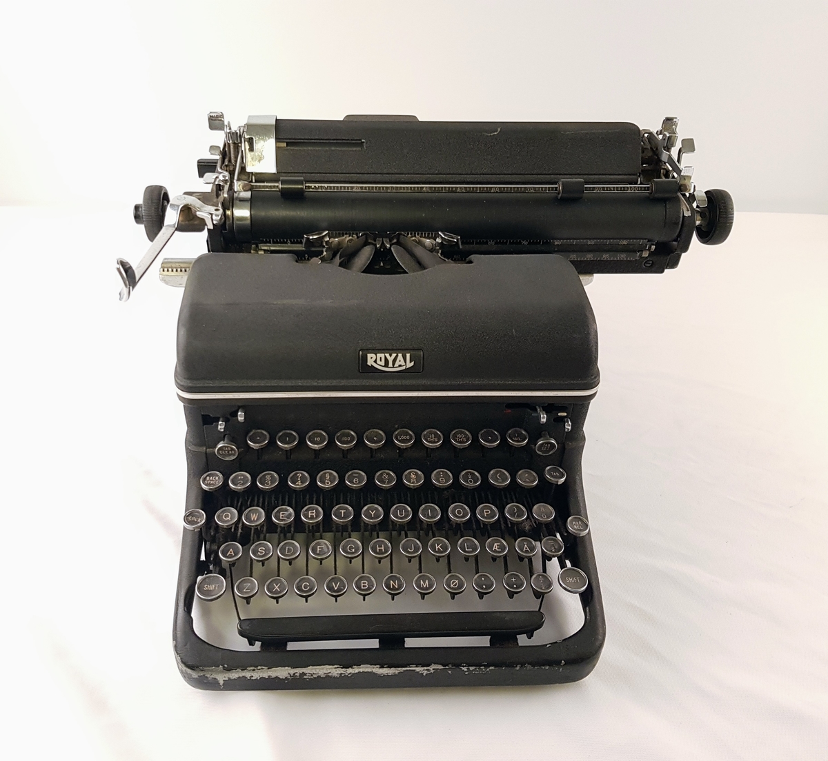 Sort Royal skrivemaskin med hus og runde taster.