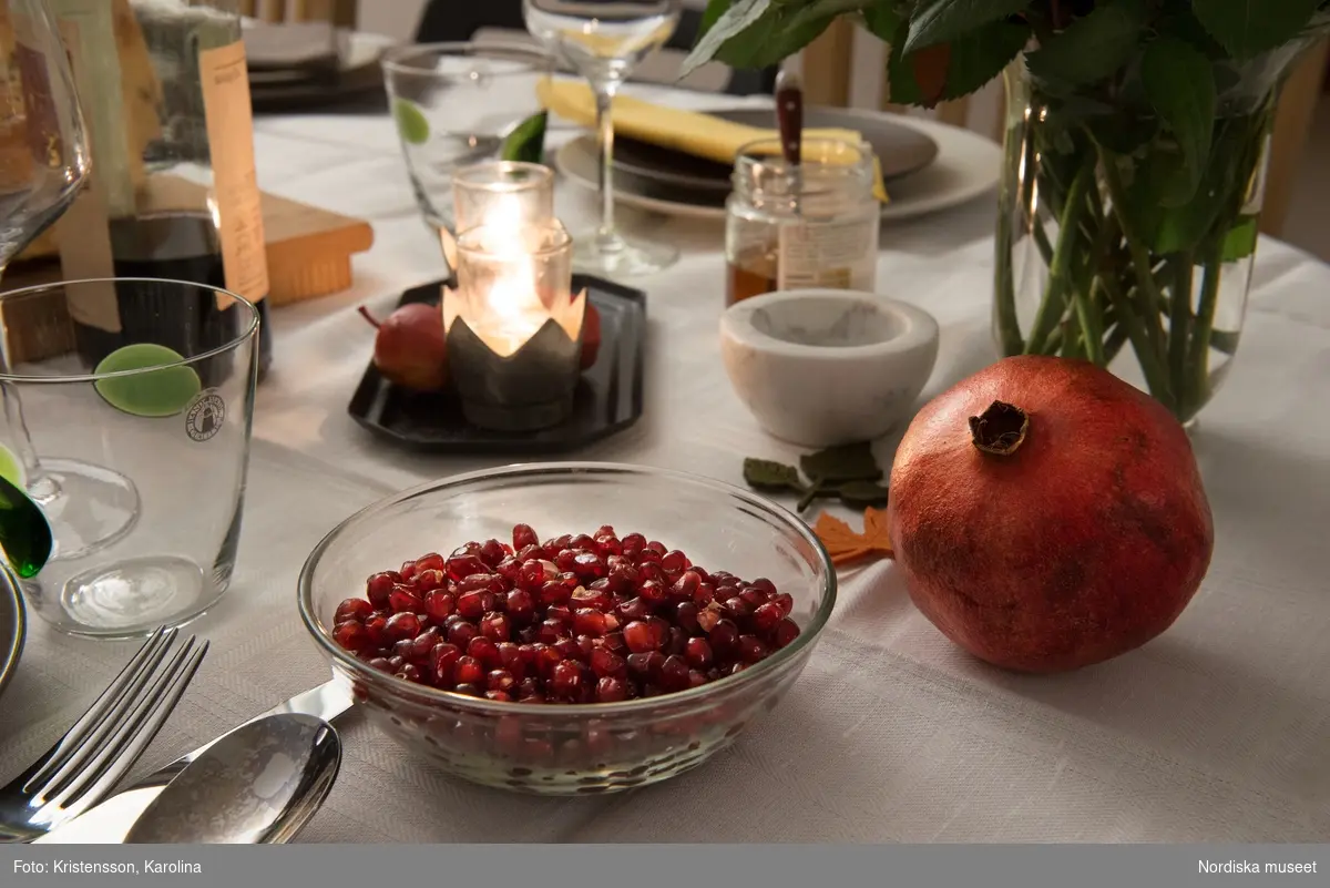 Rosh Hashana. Maten på ett judiskt nyårsbord: granatäpple, honung, bröd, äppelskivor, hummus, aubergine- och tomatröra, I köket: köttgryta (Hammin??) med sötpotatis, blomkål med citron, kycklingklubbor, ingefärssoppa, kryddris med linser och russin.