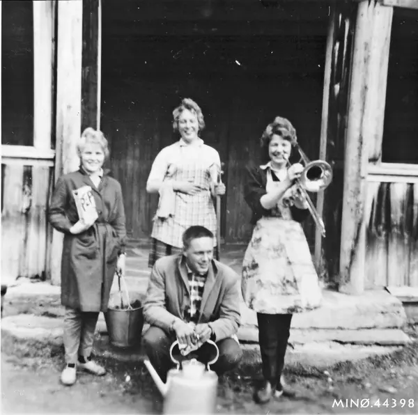 Personer, klær, kjele, musikkinstrumenter, bygning.