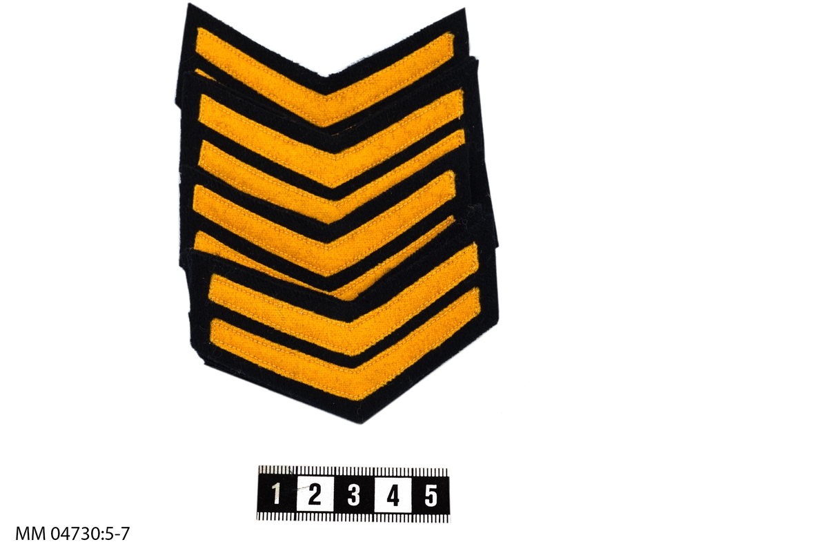 Uppmuntringstecken 1 vinkel, M/26. Av gult kläde.
För skeppsgossekorpral (senare Ordningsman) 1:a året.
9 stycken.