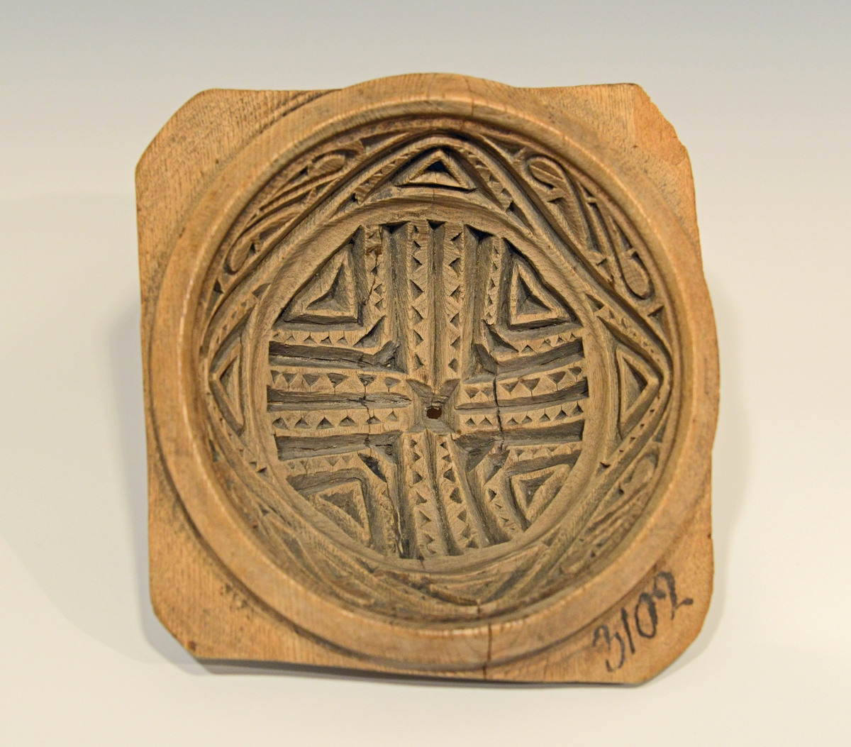 Fra protokollen: 
Rund, halvkugleformig. 4 ører som haandtak.
Smørformen har et lite hull i midten og det ene hjørnet mangler en del.