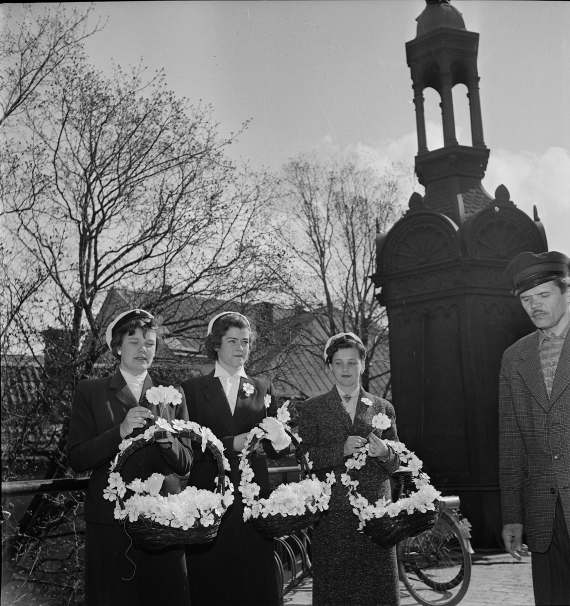 Kvinnliga studenter med vårfestblommor till Uppsala Studentkårs Vårfest i Botaniska trädgården, Uppsala 1956