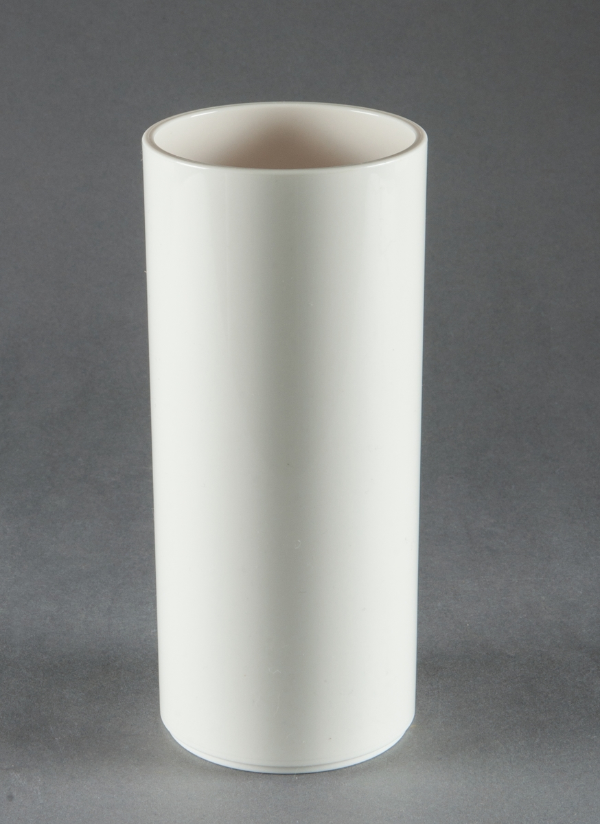 Tumbler, gjuten i vit plast. Slät cylinderformad med fotring. Design Gunnar Cyrén. Tillverkad för Dansk Designs Ltd, USA.