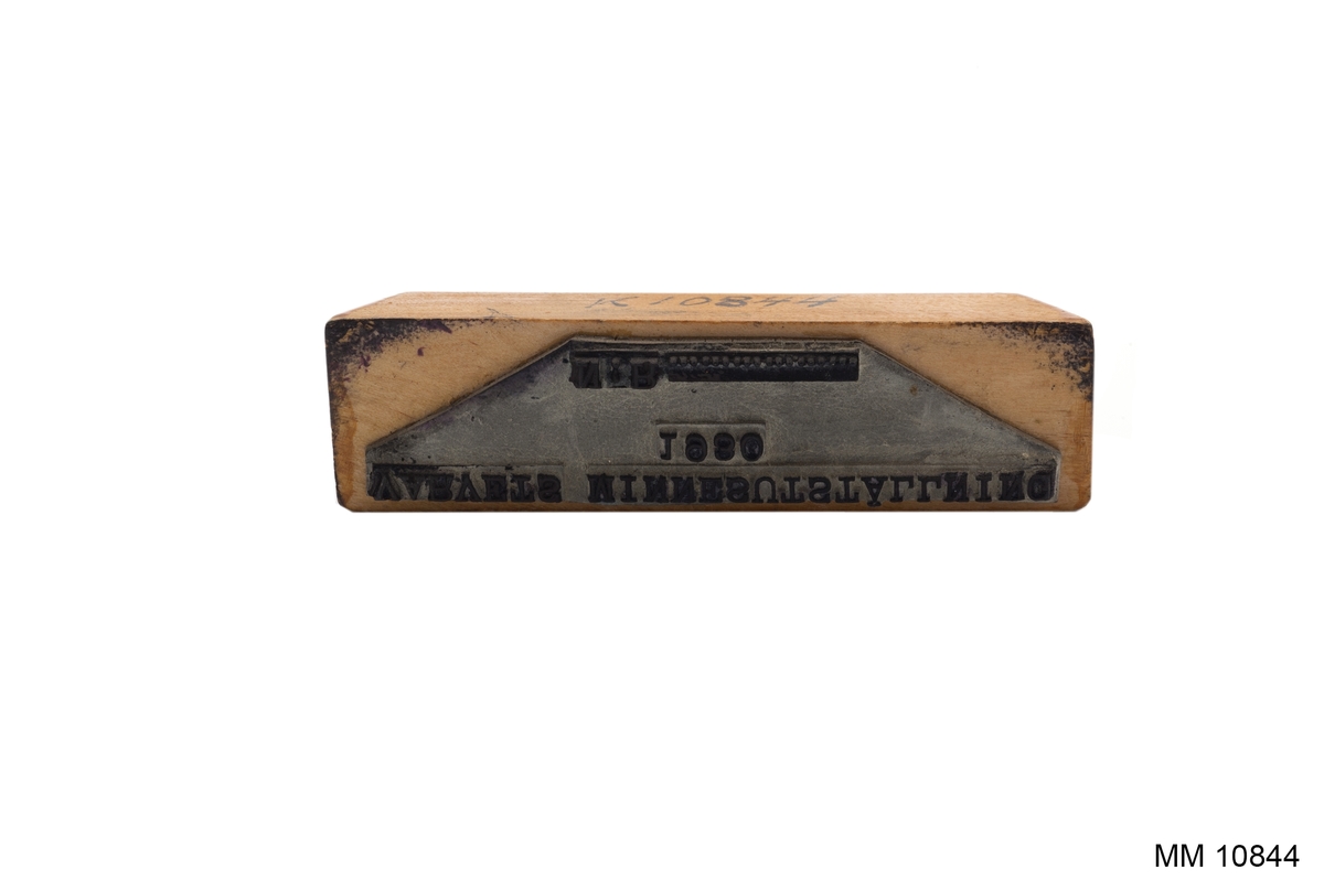 Stämpel av gummi på träplatta med svarvat träskaft, fernissat. Text: "VARVETS MINNESUTSTÄLLNING   N:R ....."