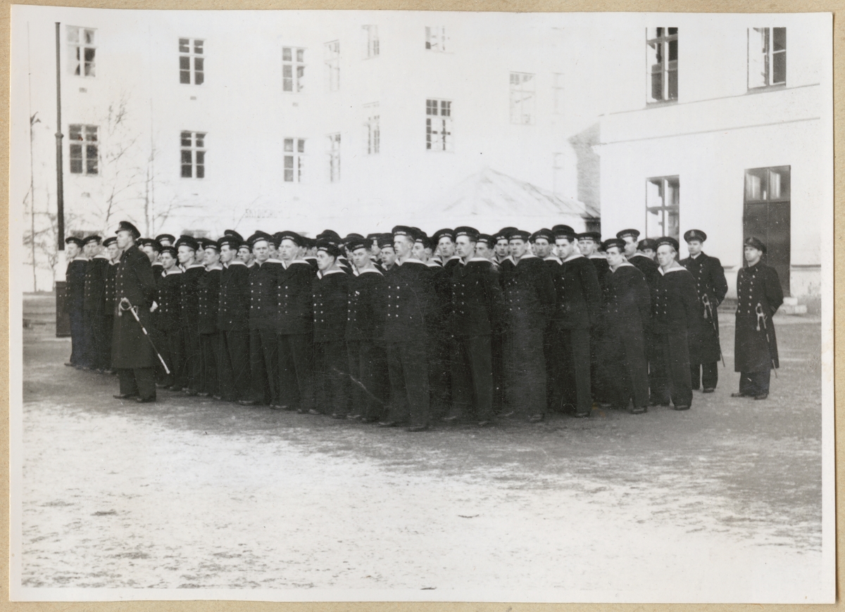 Uniformsklädda flottister står uppställda på kaserngården utanför kasern Sparre.