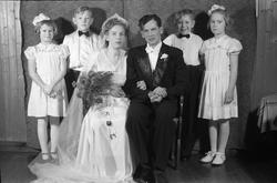 Brudepar med brudepiker og brudesvenner. Ingen av personene 