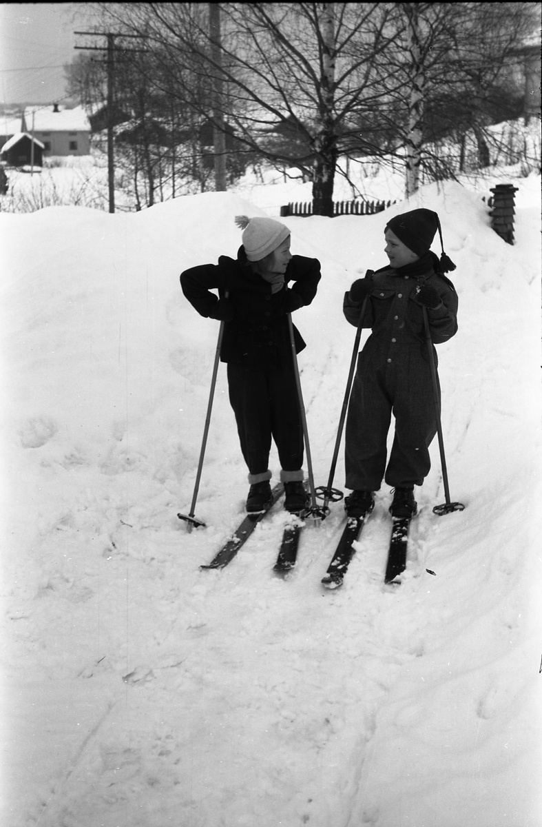 Serie på seks bilder av to uidentifisertee barn, på noen bilder på ski, på andre med spark. Stedet er gårdsplassen på Odberg på Kraby, fotografens eiendom.