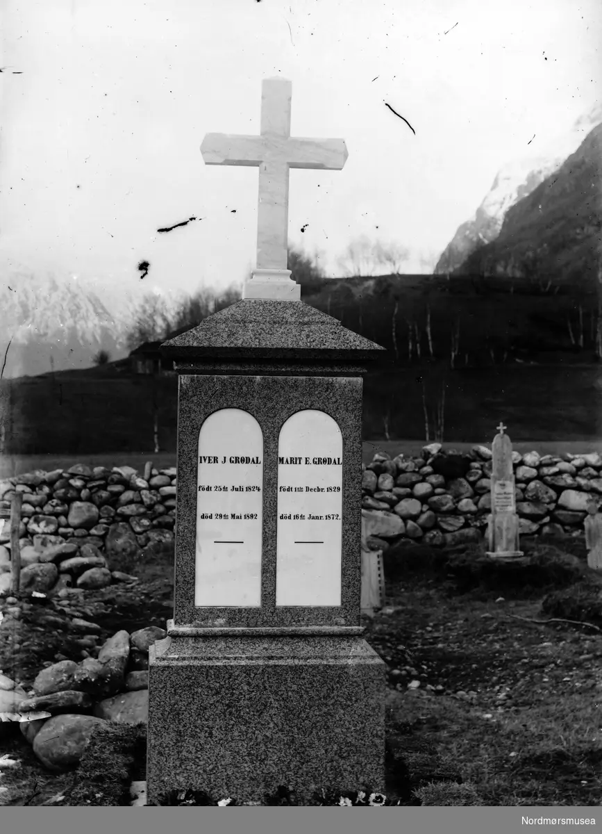 Foto av en gravstein på en kirkegård, trolig i Sunndal kommune. Gravsteinen har navnene Iver J Grødal (f. 25.07.1824 - d. 29.05.1892) og Marit E. Grødal (f. 01.12.1829 - d. 16.01.1872). Fra Sunndal museumslags fotosamlinger.