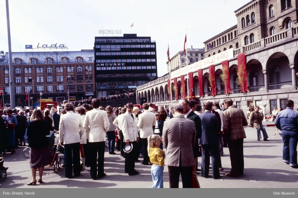 torg, mennesker, 1. mai-feiring, kontorbygninger, Venstres Hus, politistasjon, basarer, banner: "Avspenning - Ikke kald krig"
