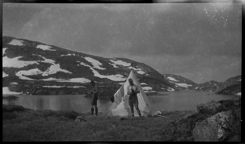 Sverre Meyer-Knutsen og Finn Johannessen på tur i fjellområdene rundt Blåsjø. Det er bilder fra fjellet, leirplasser, Grjotdokken jakthytte, Stranddalen turisthytte, en familie fra Hisdal og besøk fra to unge kvinner ved en støl.