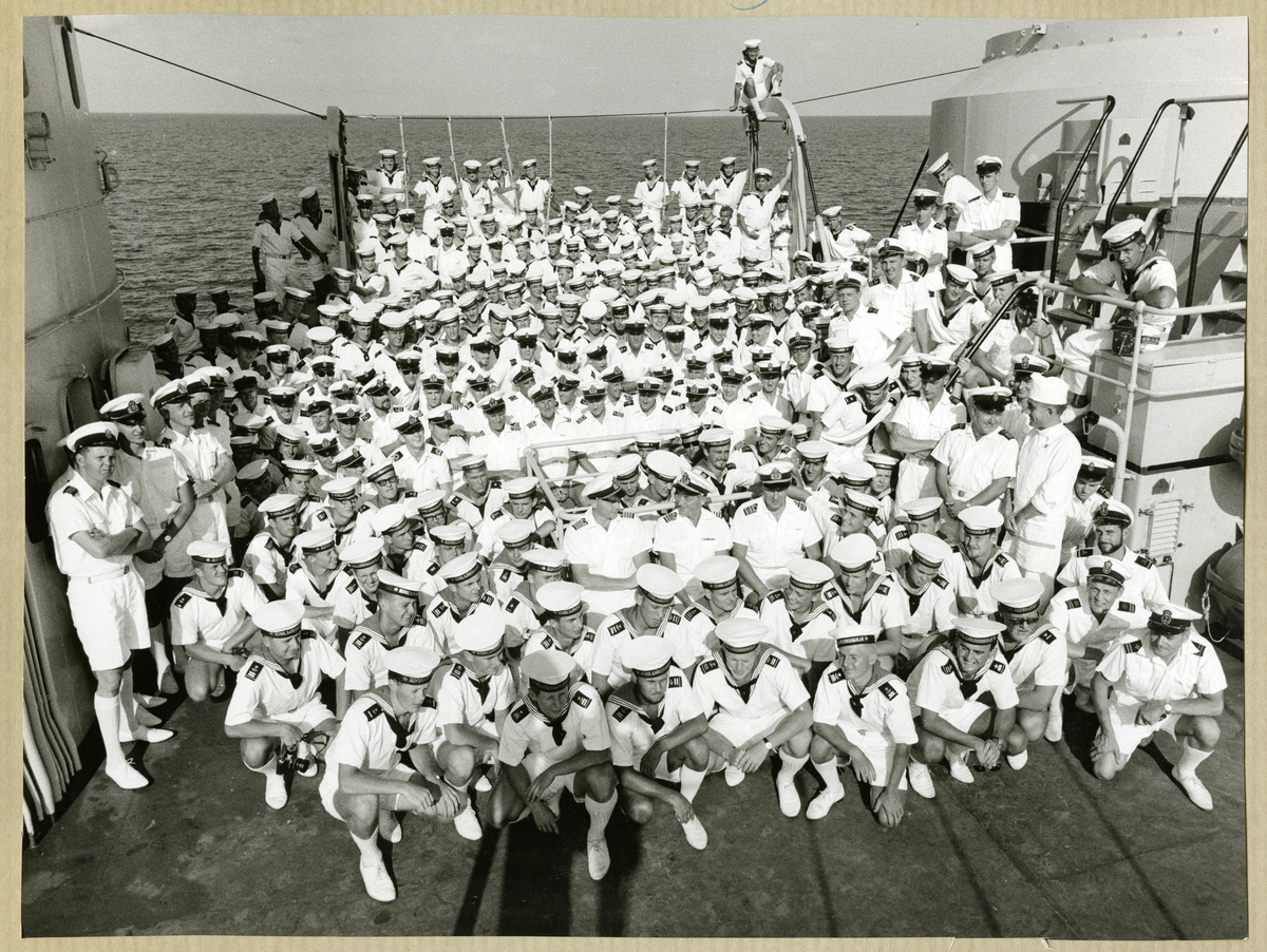 Bilden föreställer ett grupporträtt där hela besättningen av minfartyget Älvsnabben är samlad på akterskeppet under långresan 1966-1967.