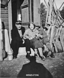 To menn og en kvinne på trappa. En av mennene er konduktør