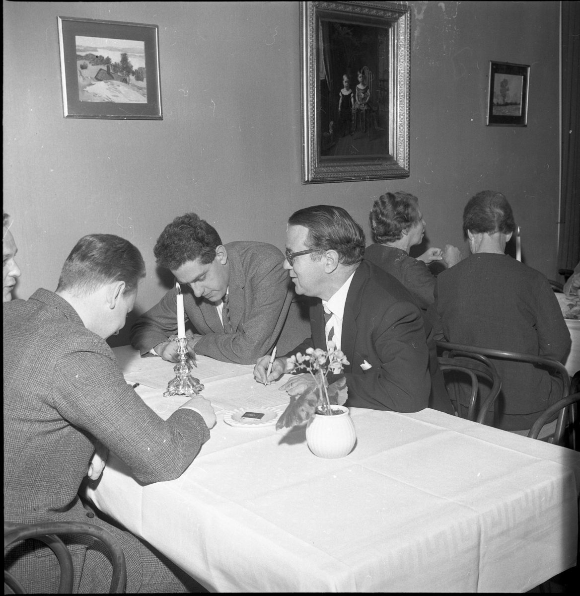 Fyra män sitter vid ett bord, lutade över papper. Rolf Möller i mitten. På hans vänstra sida sitter rektor Göte Östlund. Till vänster vid bordet bakom sitter Rut Axelsson, lärare i Örserum.