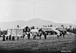 Personer oppstilt foran gardsbruk