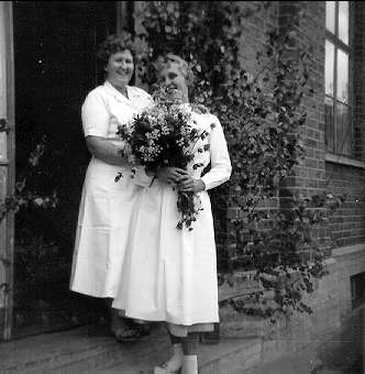 Garnisonssjukhuset Karlsborg, 1950-tal. Midsommar på sjukhuset, Mildred Stohlbin och Gun Andersson har plockat blommor. Kortet finns ej på museet, utlånat av Mildred Stohlbin.