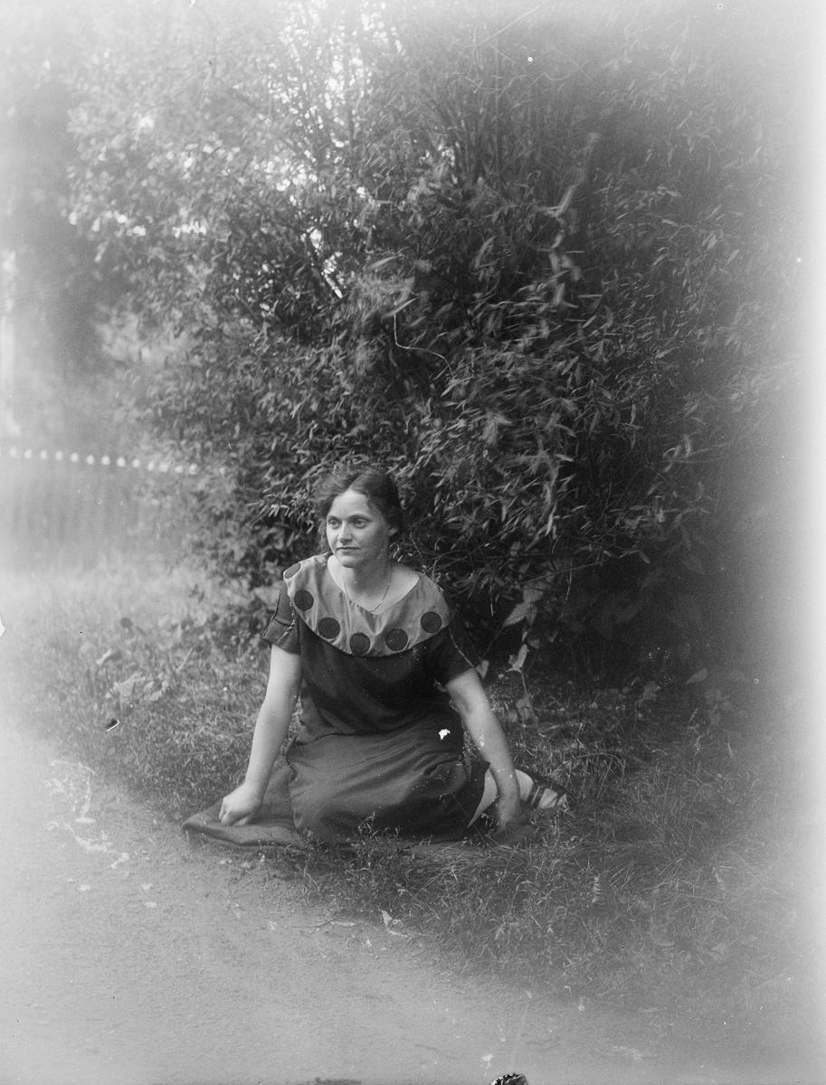 Elsa Alström från Fröslunda sitter i trädgården, Altuna socken, Uppland 1926