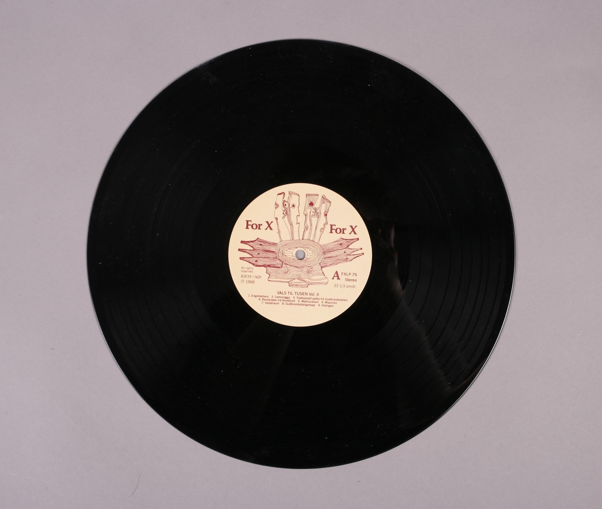 Grammofonplate i svart vinyl og plateomslag i papp. Volum II i en serie bestående av to plater. Plata ligger i en papirlomme.