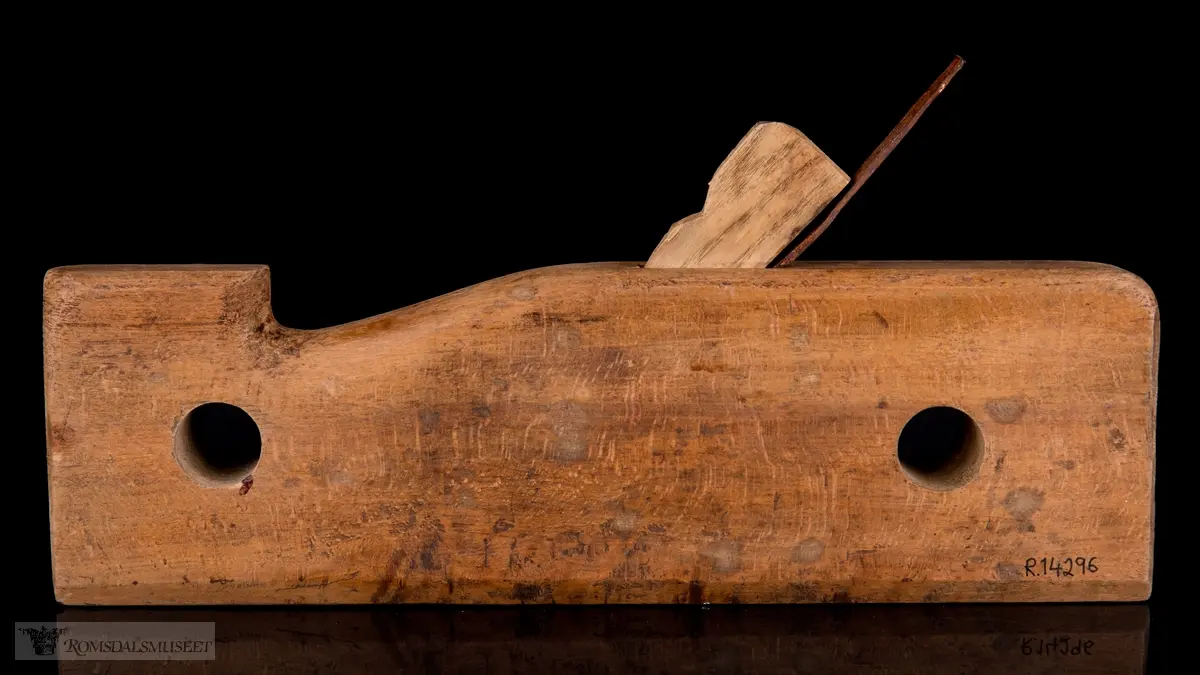 Smal rektangulær høvelstokk med tilskåret horn i forkant og avrundede hjørner. To gjennomgående opphengshull. Stokken er skåret slik at det er en støttekant ved siden av sålen. Gaffelformet høvelblad der et spor går langs sålen mellom de to tennene for høvling av fjær.