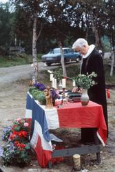 Prost Svartvasmo ved flaggdekket alter under en utegudstjene
