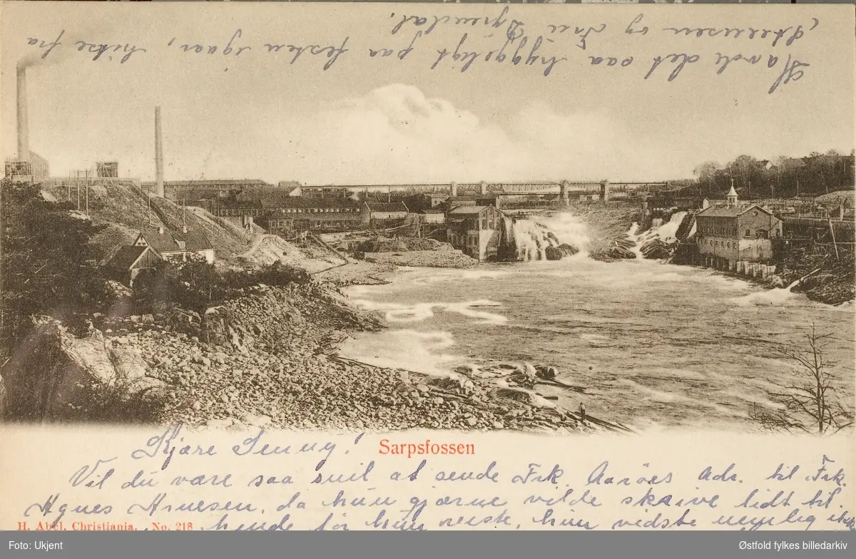 Postkort, lystrykk av Sarpsfossen og industri på begge sider av Glomma. Poststemplet 1904.