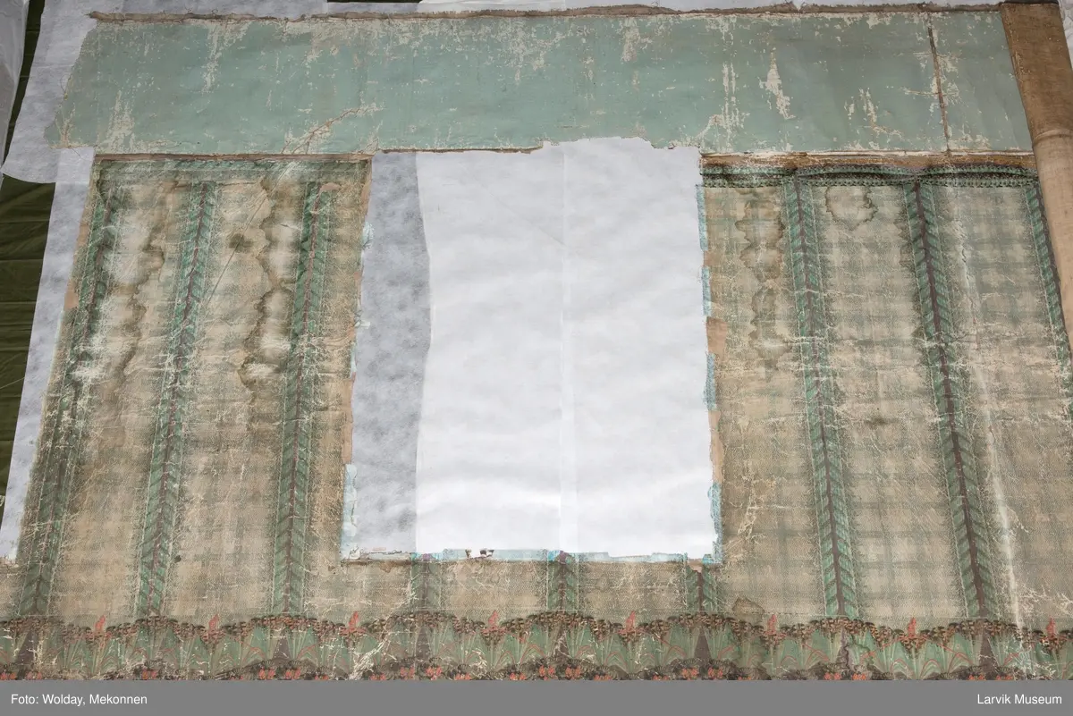 |Tapeten er påmalt tapetborder og brystning. Fra Hovland gård i Larvik.
Den øverste, brede borden: Gerlander/draperi med blomsterranker.
Den nederste, smalere borden: Tekstilbord med blomster. Øver døren til høyre: Stillebenmotiv med blomster og frukt.