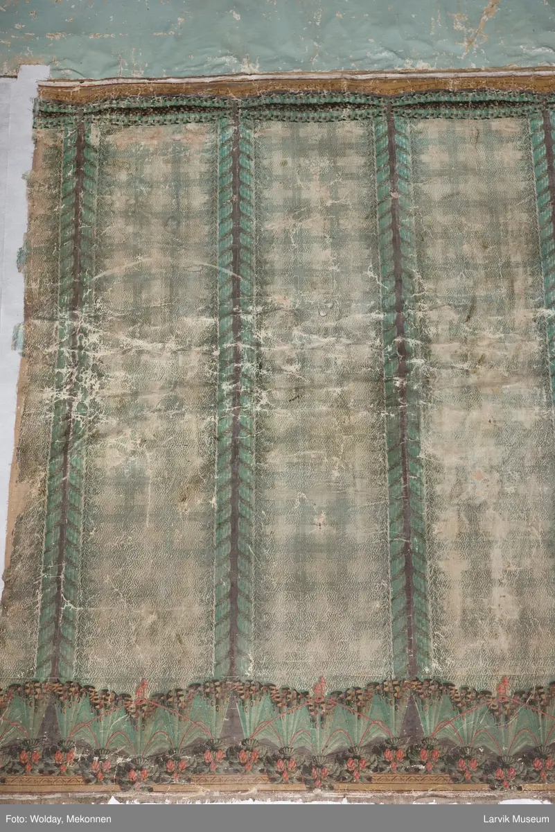 |Tapeten er påmalt tapetborder og brystning. Fra Hovland gård i Larvik.
Den øverste, brede borden: Gerlander/draperi med blomsterranker.
Den nederste, smalere borden: Tekstilbord med blomster. Øver døren til høyre: Stillebenmotiv med blomster og frukt.