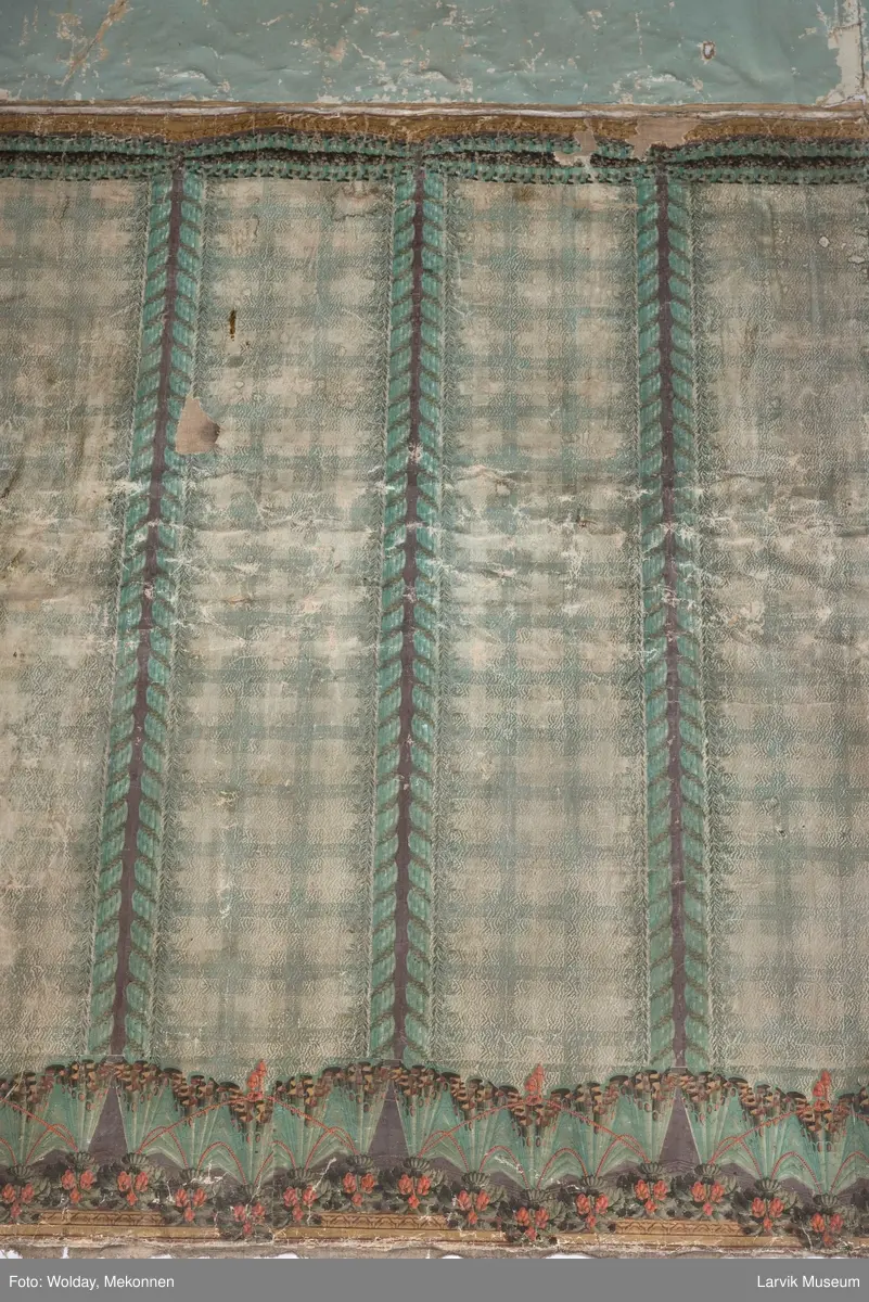 |Tapeten er påmalt tapetborder og brystning. Fra Hovland gård i Larvik.
Den øverste, brede borden: Gerlander/draperi med blomsterranker.
Den nederste, smalere borden: Tekstilbord med blomster. Øver døren til høyre: Stillebenmotiv med blomster og frukt.