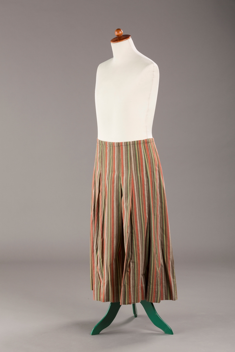 Stripete bomullsskjørt med nedsydde legg, uten linning, lukkes med trykknapper.