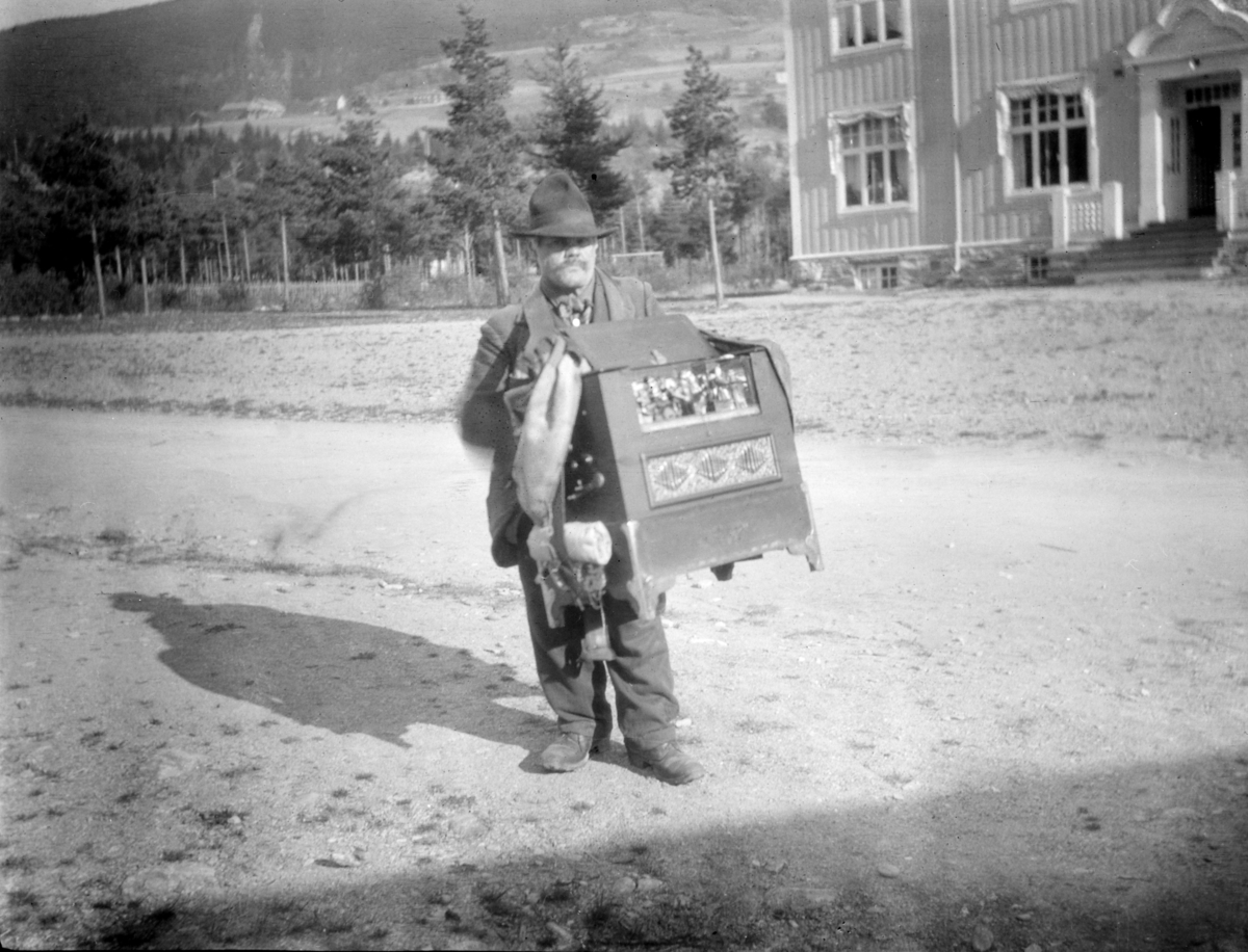 Mann med lirekasse foran kommuneplassen Ringebu.