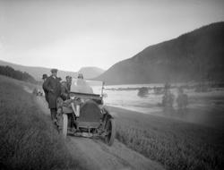 Flomstor elv. Biler kjører langs elven.