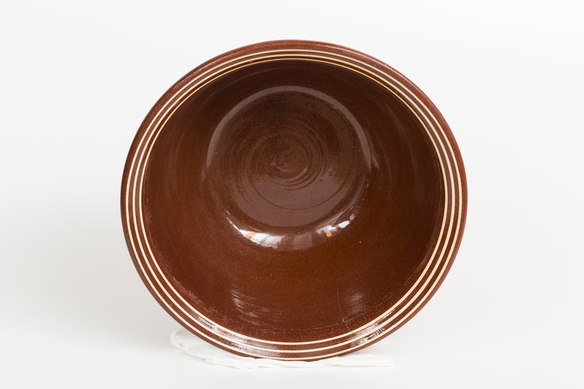 Brun bolle i keramikk med 3 gule striper. Glasert på innside.