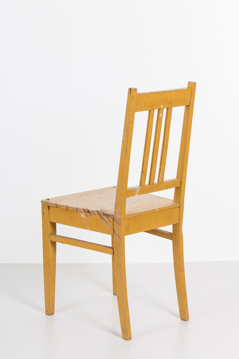 Stol i treverk, malt. Rygg med spiler. Den ene stolen har vært brukt betydelig røffere enn den andre.