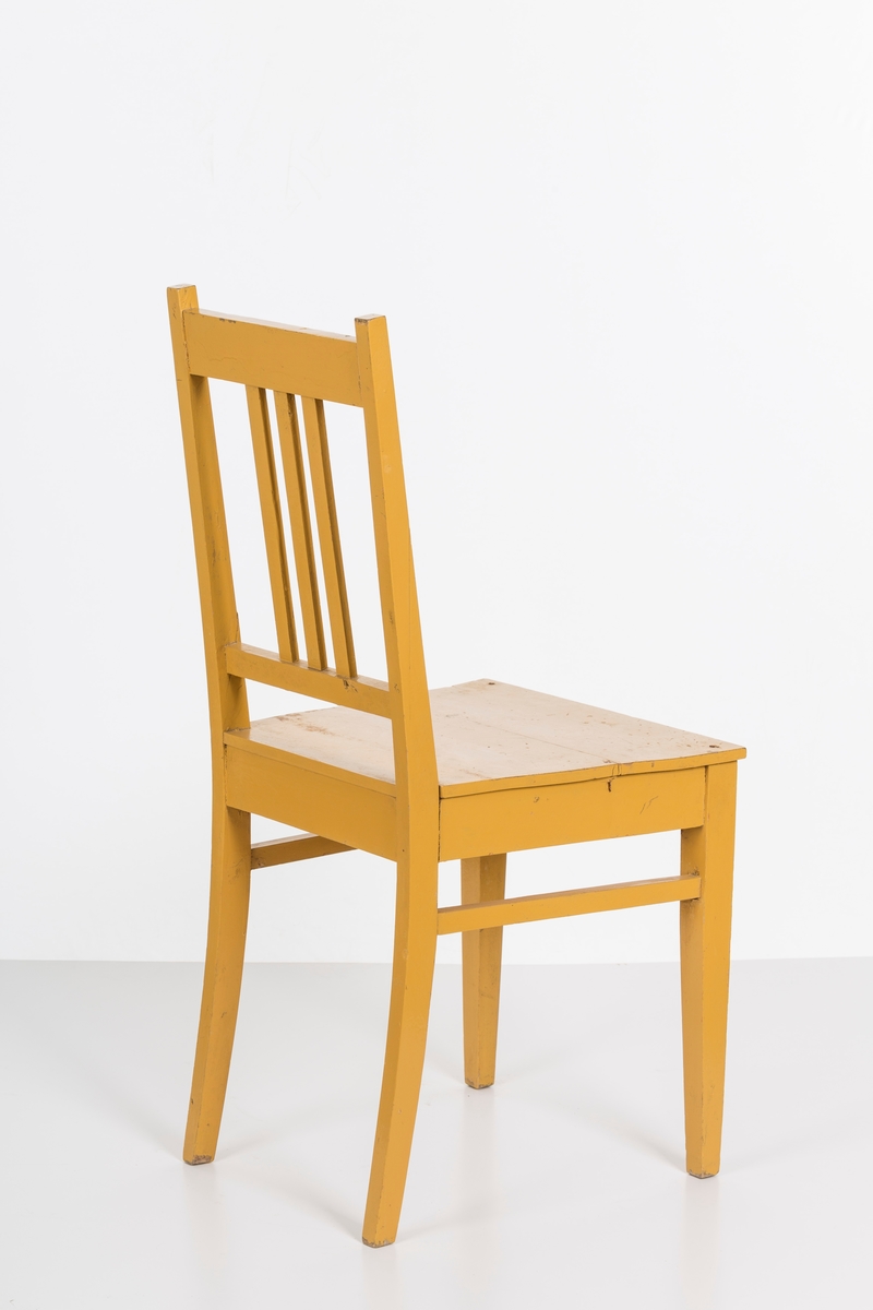 Stol i treverk, malt. Rygg med spiler. Den ene stolen har vært brukt betydelig røffere enn den andre.