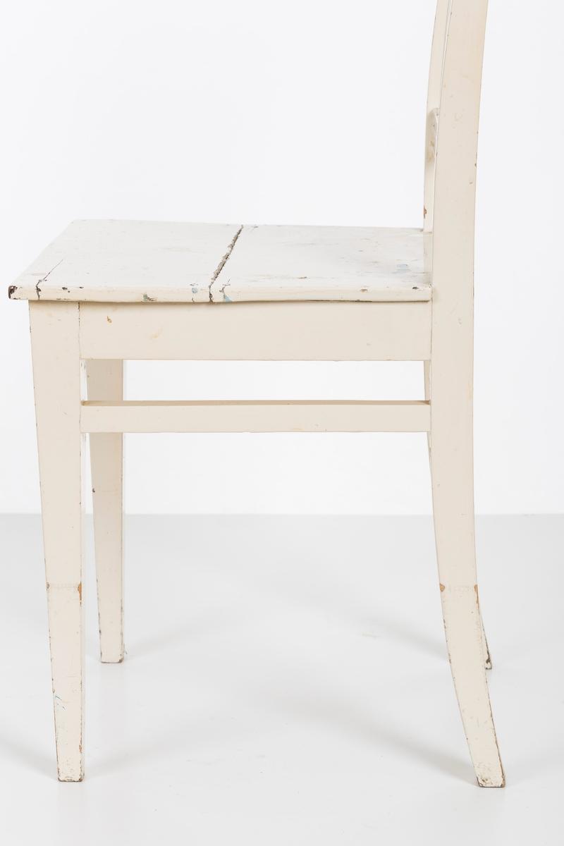 Hvitmalt spisestuestol. Sprosser i rygg og mellom stolbeina på venstre og høyre side.