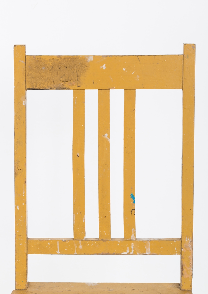 Stol i treverk, malt. Rygg med spiler. Den ene stolen har vært brukt betydelig røffere enn den andre.