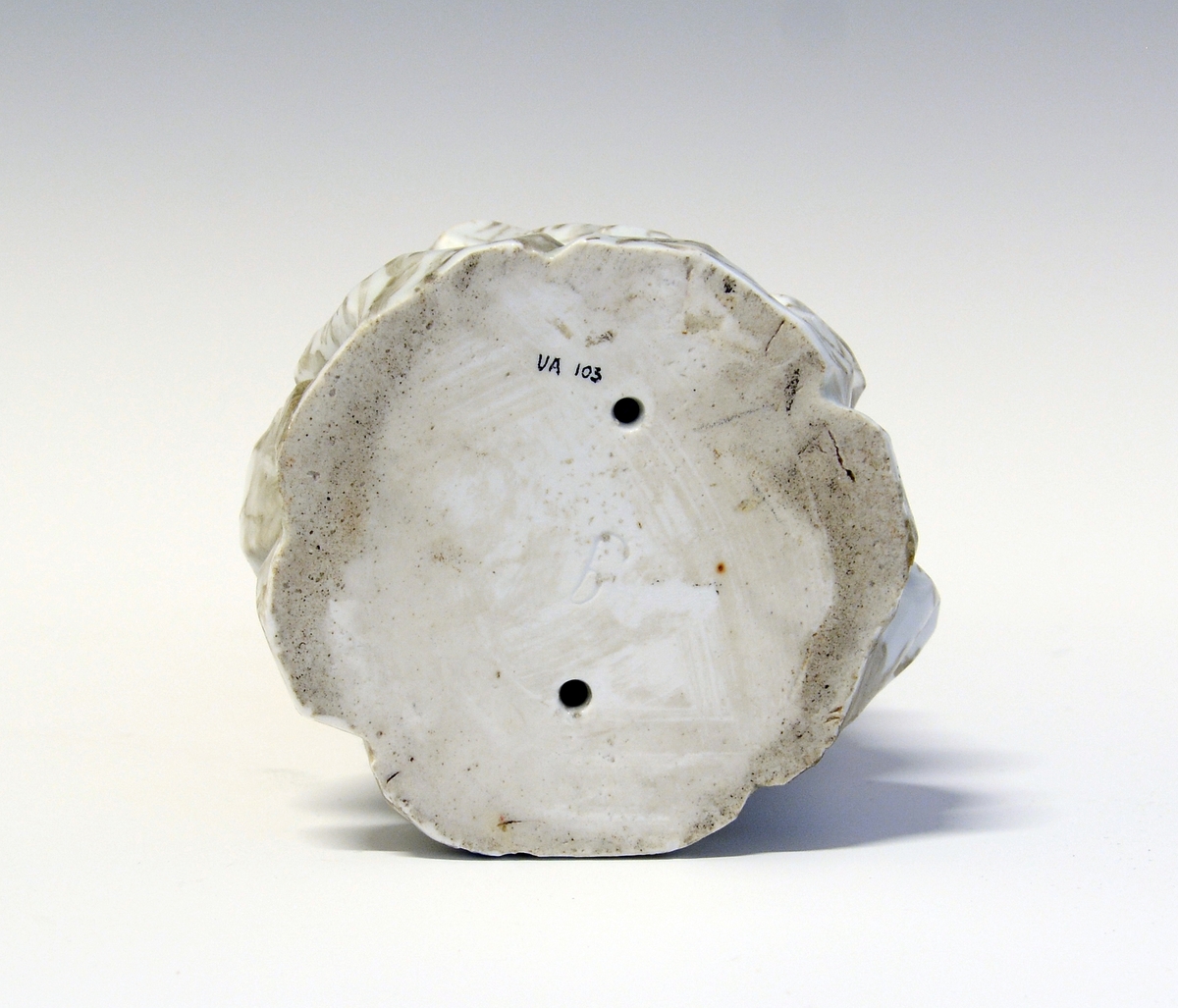 Dionysos kryster druer, og spiser fra en drueklase, Pan sittende ved hans føtter, begge på en immitert bergsokkel.