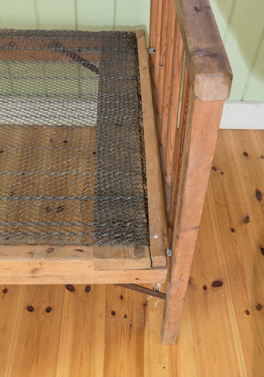 Sengeramme med sangegavler bestående av staver. Ubehandlet tre. Avstivere i metall. Nettingbunn.