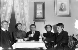 To kvinner og tre menn ved kaffibordet, ukjende