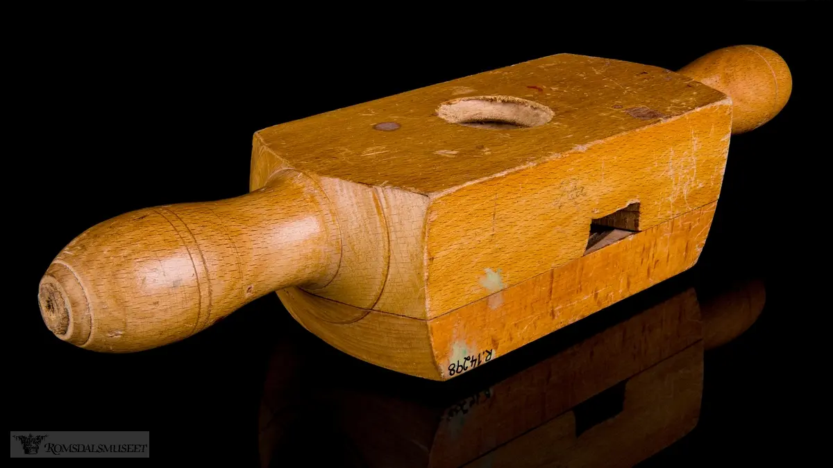 Rektangulær trekloss bestående av to deler som er festet til hverandre med skruer. En V- formet kniv er festet mellom delene og stikker fram i det gjennomgående hullet hvor treemnene gjenges. Et lite sponhus er skåret ut i skjøten mellom de to delene. Dreide trehåndtak på hver side.