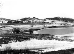 Hobøl kirke med omgivelser, elva i forgrunnen fra vest, ca. 