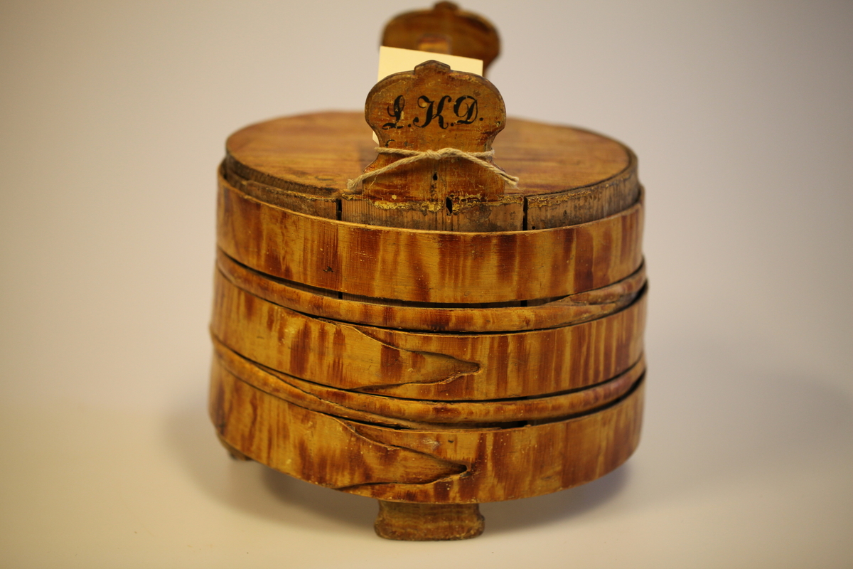 Lagging belagt med tette sveiperinger. Lokk, to ører  og tre bein. Formen er rund, lokk er nedfelt og har avlang hank. Sveip med skjøter (5 stk.) (gjorder). Påmalt gyllengul farge, ådringsmalt.