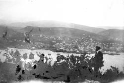 Kvinner og menn på utflukt til Gangsåstoppen. Byen i bakgrun