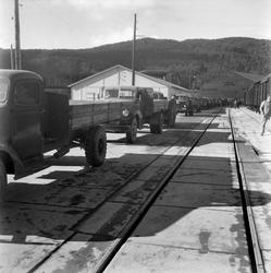 Lastebiler i kø for å losse jernbanevogner på Ila pir